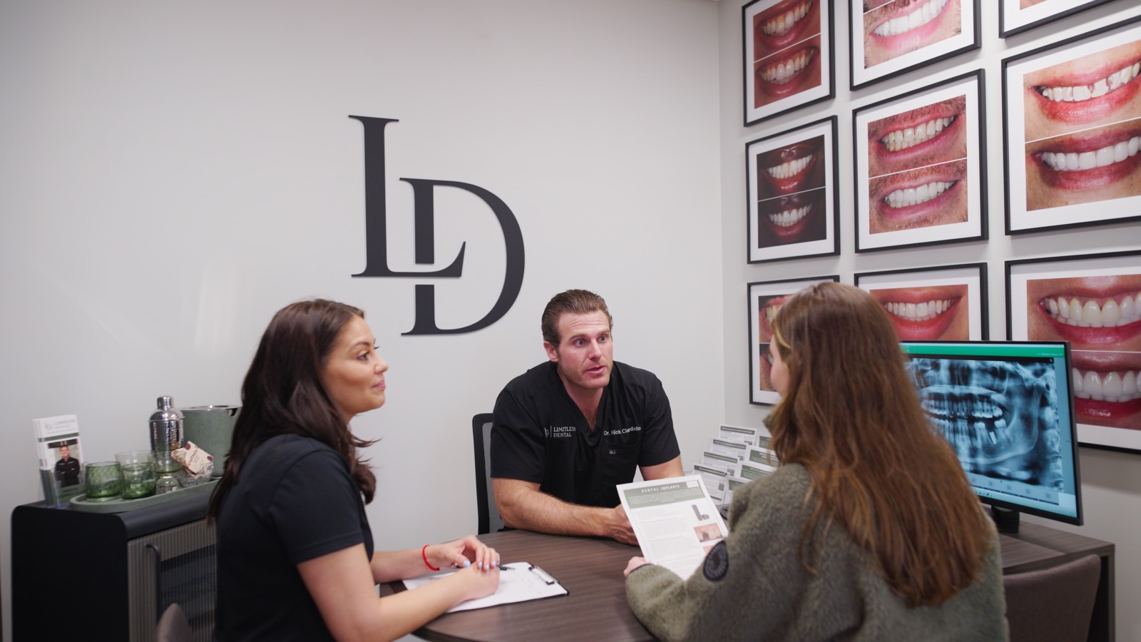 Dr. Nick Ciardiello reviewing a digital smile design on screen with patients at Limitless Dental in Jersey City.
