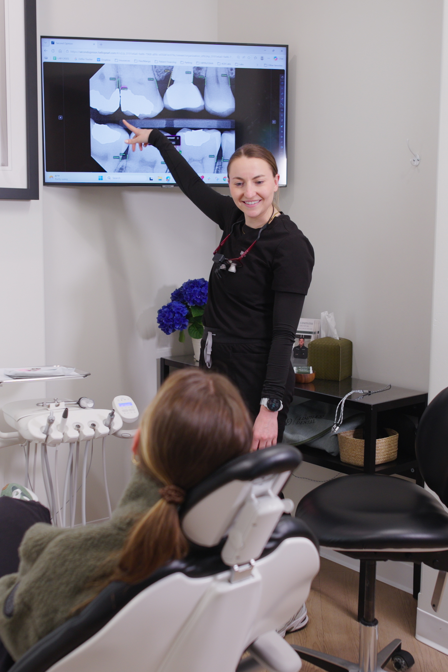 Dr. Nick Ciardiello pointing at a patient x-ray on screen, explaining findings to a seated patient at Limitless Dental in Jersey City.