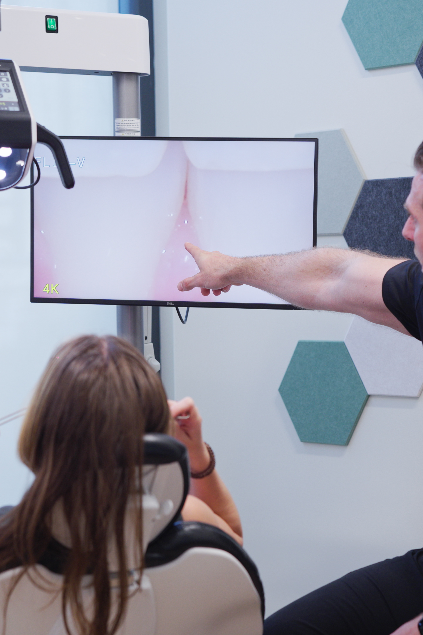 Dr. Nick Ciardiello of Limitless Dental in Jersey City pointing at a 4K monitor showing a patient's teeth during a digital smile design consultation