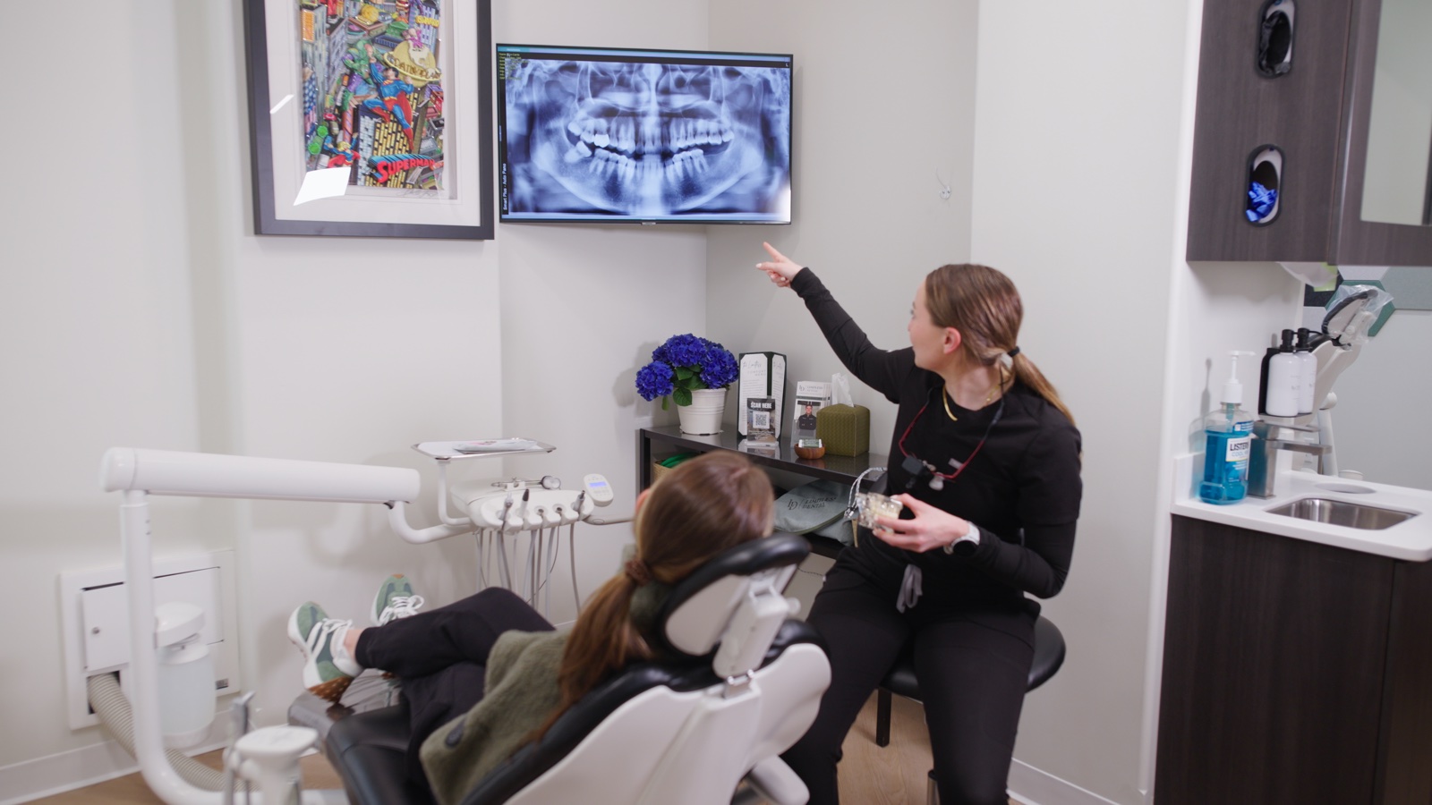 Dentist reviewing a panoramic dental X-ray on screen with Pearl AI detection overlay during a comprehensive screening at Limitless Dental, Jersey City.