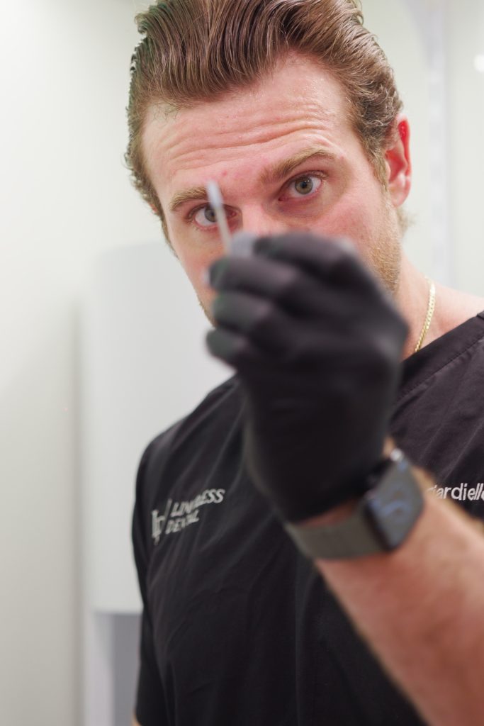 Dr. Nick Ciardiello at Limitless Dental in Jersey City demonstrating dental needle for numbing during an emergency dental procedure