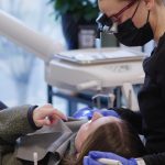 Dr. Nick Ciardiello at Limitless Dental in Jersey City examining a patient with dental magnification loupes during a root canal or extraction consultation