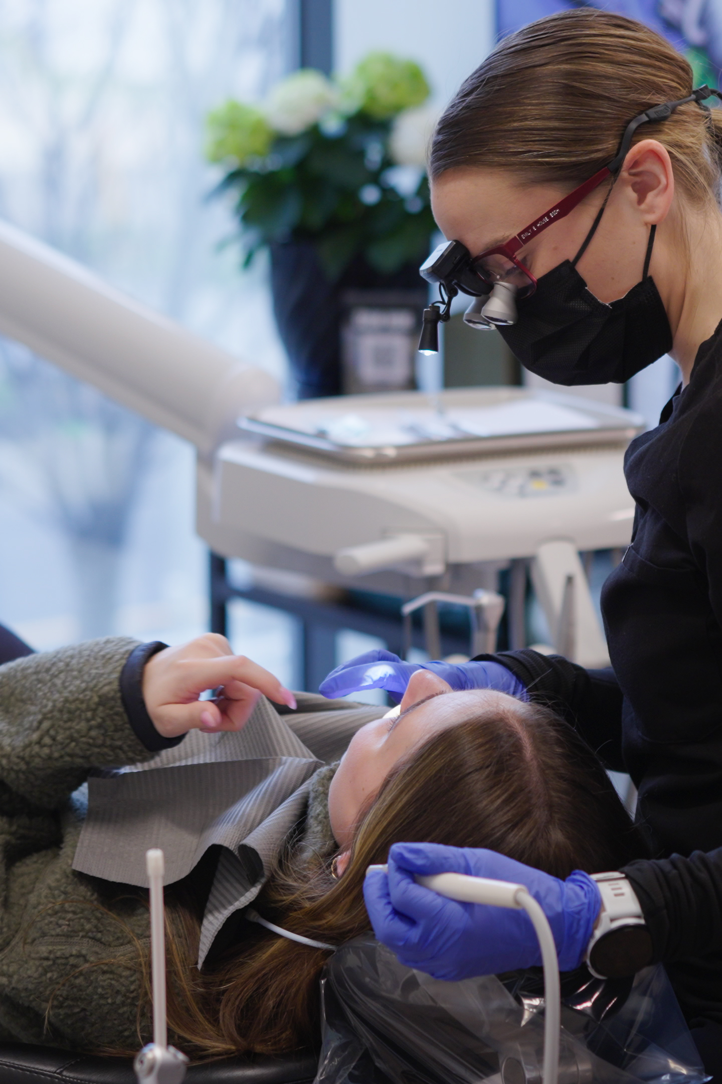 Dr. Nick Ciardiello at Limitless Dental in Jersey City examining a patient with dental magnification loupes during a root canal or extraction consultation